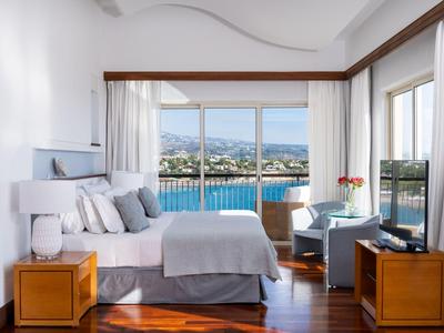 Helles Hotelzimmer mit Blick auf das Meer, Balkon und modernem Interieur.