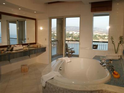 Großes Bad mit rundem weißen Whirlpool, Fenster mit Bergblick und grauen Fliesenboden.