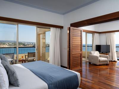 Elegantes Hotelzimmer mit Meerblick, Holzboden und modernem Interieur.