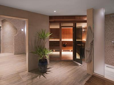 Nowoczesna strefa spa z sauną, drewnianą podłogą i roślinami w hotelu.