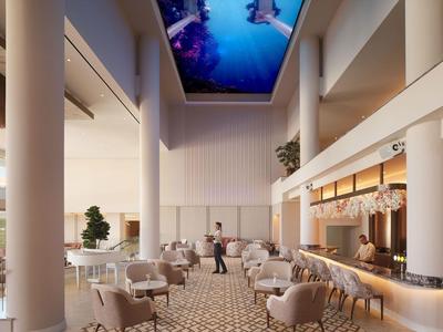 Jasna restauracja hotelowa z wysokimi kolumnami, wygodnymi fotelami i dużym dziełem na suficie.