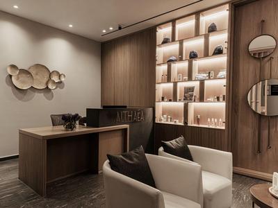 Modern hotel lobby with wood paneling, shelves, and cozy seating.