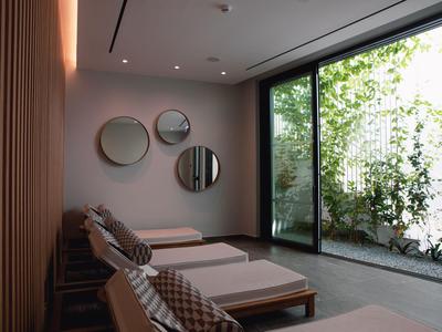 Relaxation room with lounge chairs and large window overlooking a green garden.