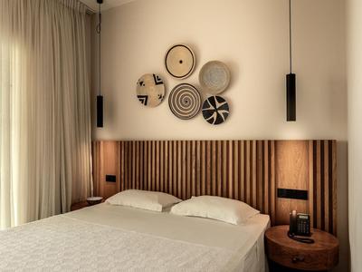 Bedroom with double bed, wooden paneling, decorative wall plates, and natural light.