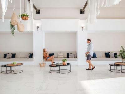 Moderner, heller Raum mit weißen Wänden, zwei Personen und runden Tischen mit Pflanzen.