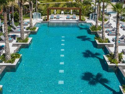 Nowoczesny basen na zewnątrz z leżakami i palmami w ośrodku hotelowym