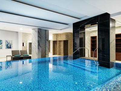 Heller, moderner Innenpool mit blau schimmerndem Wasser, Sitzbereich und elegantem Marmor-Design.