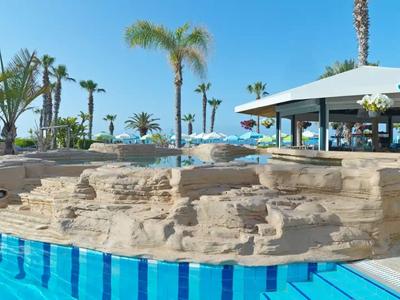 Luxuriöser Poolbereich mit Wasserfall und Palmen in einem Urlaubsresort.