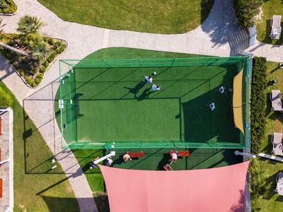 Vogelperspektive eines kleinen grünen Minigolfplatzes mit einem Spieler.