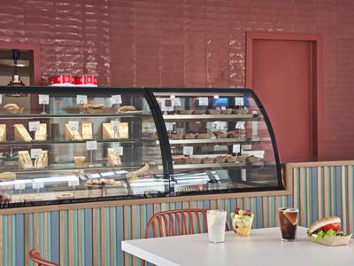 Moderne glazen toonbank gevuld met gebak in een café met kleurrijke stoelen