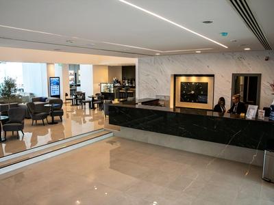 Moderner Hotel-Lobby-Bereich mit Rezeption, Sitzgelegenheiten und heller, offener Gestaltung.