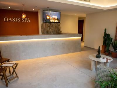 Moderner Spa-Empfangsbereich mit beleuchtetem Tresen und gemütlichen Sitzgelegenheiten.
