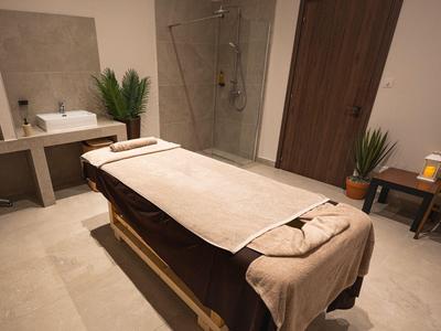 Moderner Spa-Raum mit Massageliege, Handtüchern und beruhigendem Ambiente.