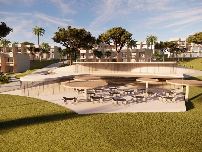 Modernes, halb unterirdisches Gebäude mit Terrasse, Sitzbereichen und umliegendem Rasen in sonniger Umgebung.