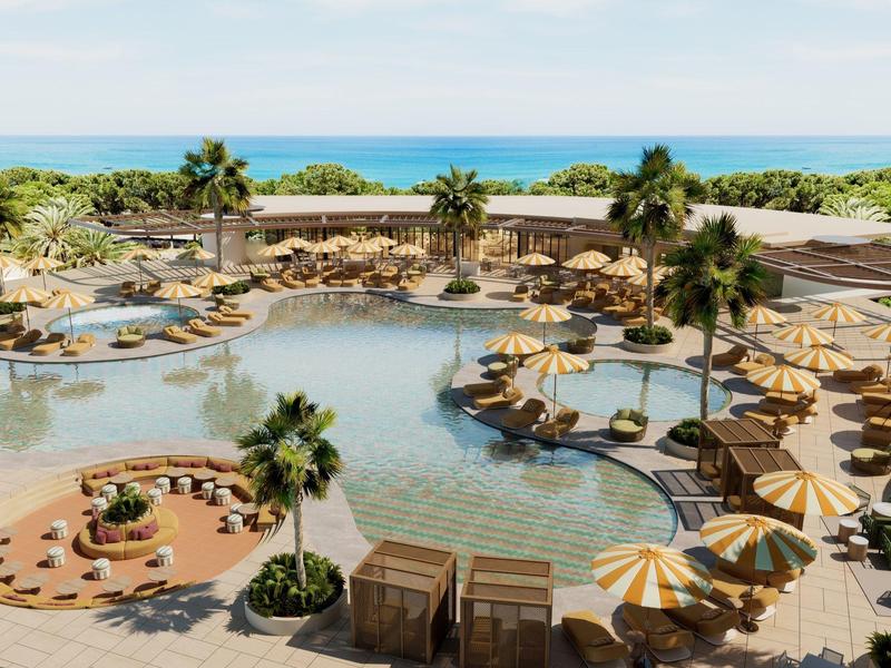 Großer Hotelpool mit Sonnenschirmen, Liegen und Palmen am Meer