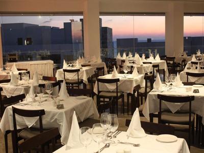 Elegantes Restaurant mit eingedeckten Tischen und Blick auf die Dämmerung.