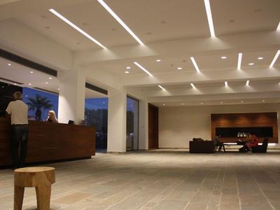 Geräumige Hotelhalle mit moderner Beleuchtung, Rezeption und Sitzgelegenheiten am Abend.