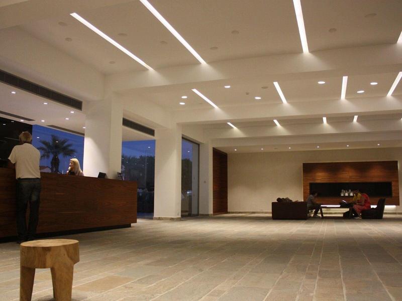 Moderne Hotellobby mit großem Empfangstresen, minimalistischer Einrichtung und heller Beleuchtung.