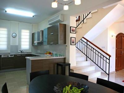 Moderner Küchenbereich mit Essplatz und Treppe im Hintergrund in einer Ferienwohnung.