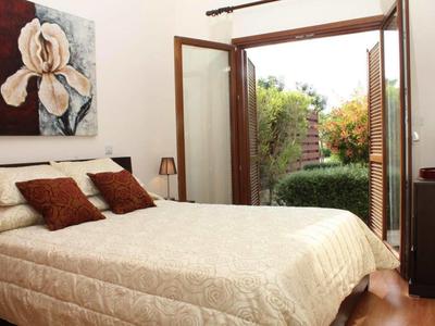 Gemütliches Schlafzimmer mit großem Bett und offenem Tür zum Garten.