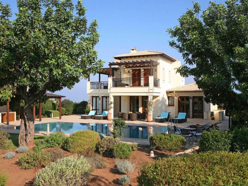 Moderner weißer zweistöckiger Haus mit Pool, umgeben von grünen Bäumen und gepflegtem Garten.