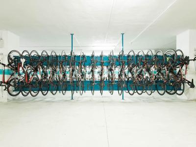 Zweistöckiger Fahrradständer in einer Parkgarage mit mehreren abgestellten Fahrrädern.