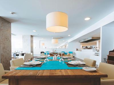 Salle à manger moderne et élégante avec table en bois et chemins de table bleus dans un restaurant d'hôtel.