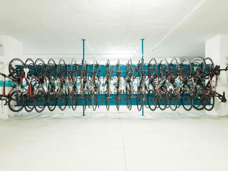 Rangées de vélos suspendus des deux côtés d'un porte-vélos suspendu dans un garage.