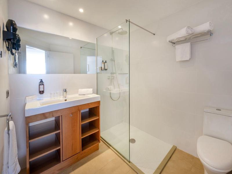 Modernes Badezimmer mit Duschkabine, Waschtisch mit Spiegel und Toilette.