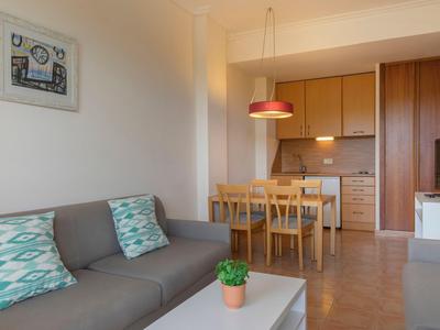 Moderner Wohnbereich mit Sofa, Esstisch und offener Küche in warmen Farben