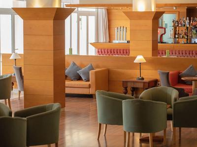 Lounge dell'hotel moderna con sedie comode, divani e pannelli di legno caldi.