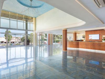 Luminosa hall d'hotel con colonne moderne, reception e grandi finestre di vetro