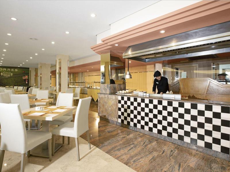 Moderní restaurace s kostkovaným pultem a bílými židlemi.