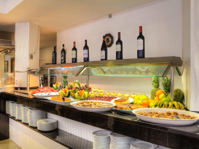 Buffet avec fruits, salades et bouteilles de vin dans un restaurant d'hôtel.
