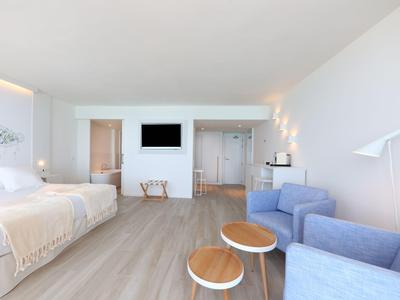 Helles, modernes Hotelzimmer mit zwei Betten, Sitzecke und minimalistischem Design.
