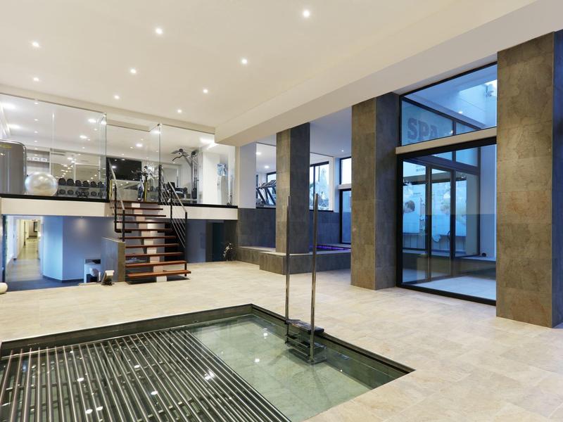 Área interior moderna con piscina cuadrada y grandes ventanales en un hotel.