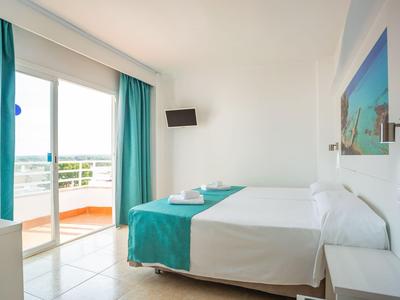 Modernes Hotelzimmer mit Doppelbett, Balkon und türkisfarbenen Vorhängen.