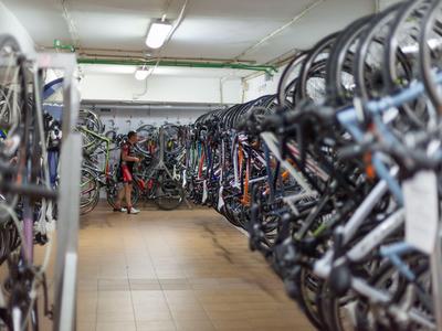 Numerosas bicicletas están alineadas lado a lado en un sótano bien iluminado para bicicletas.