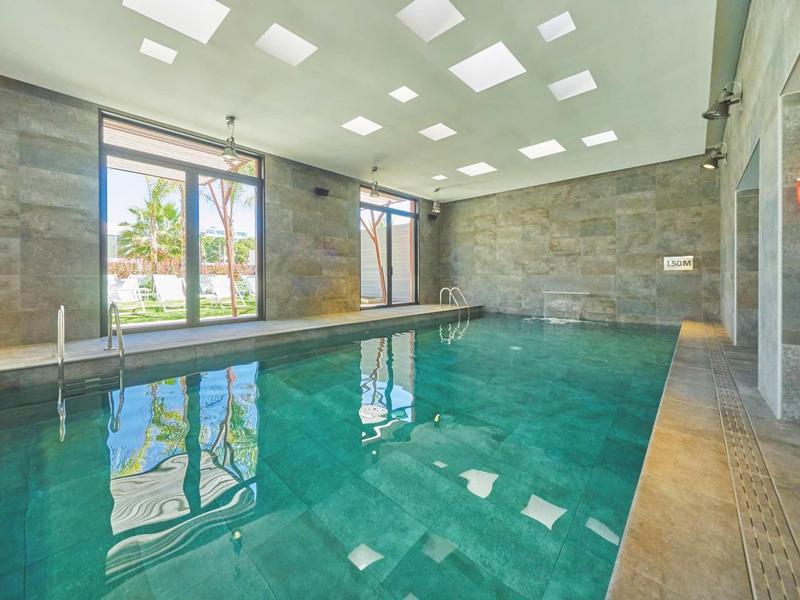 Wnętrze z czystym basenem, dużymi oknami i naturalnym światłem przez świetliki