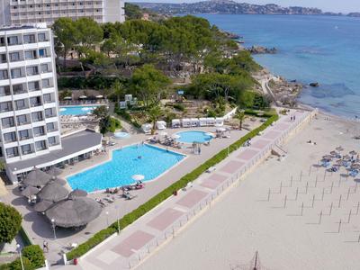 Hotel z basenem i parasolami na plaży wzdłuż wybrzeża z czystą wodą.