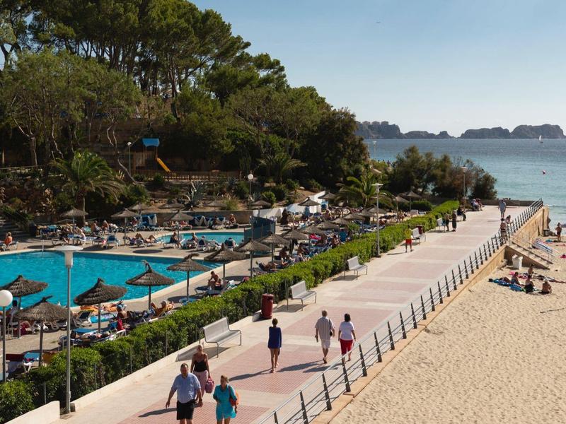 Plaża, basen, palmy, promenada z ludźmi, parasole w stronę morza.