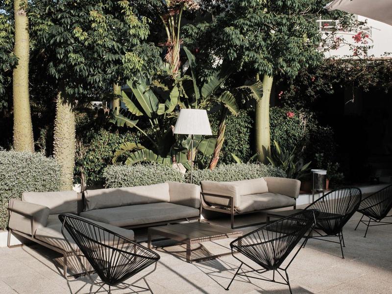 Nowoczesna przestrzeń na zewnątrz z meblami wypoczynkowymi i roślinami do relaksu na świeżym powietrzu.