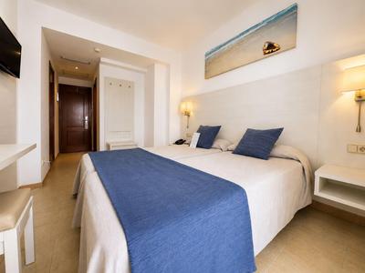 Modernes Hotelzimmer mit Doppelbett, blauen Akzenten und minimalistischer Einrichtung.