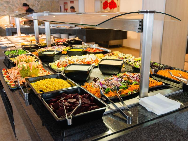 Buffet con diversi piatti caldi e freddi in una cucina d'hotel