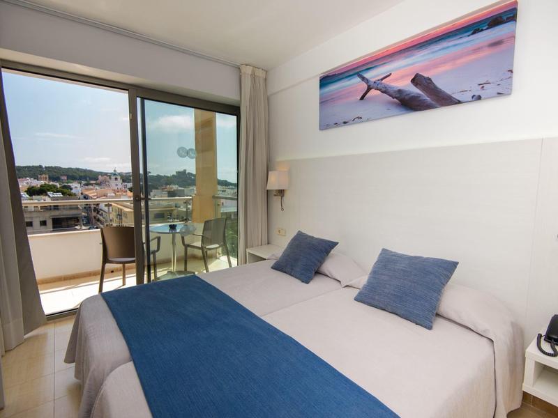 Camera d'hotel moderna con letto matrimoniale, balcone e vista sulla città