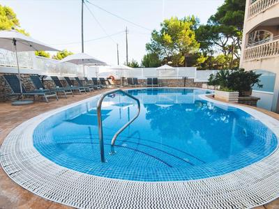 Runder Außenpool mit Stufen und Liegestühlen unter Sonnenschirmen auf der Terrasse.