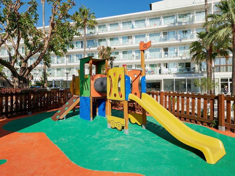 Plac zabaw zjeżdżalnie i sprzęt do wspinaczki przed budynkiem hotelu.