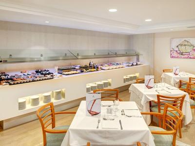 Moderní jídelna s bufetem a prostřenými stoly připravenými na servis.