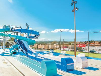 Leeg blauw waterglijbaangebied onder heldere lucht bij een hotelzwembadcomplex.