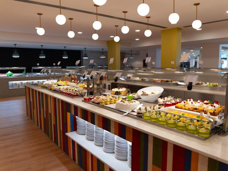 Buffet met diverse gerechten in een modern restaurant met een kleurrijke toonbank.